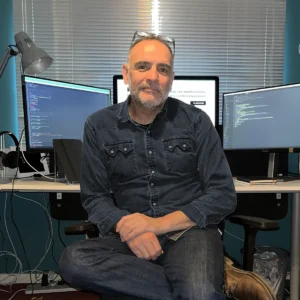 Chris Manfredi, Freelance Website Designer and SEO Consultant, sitting at his desk